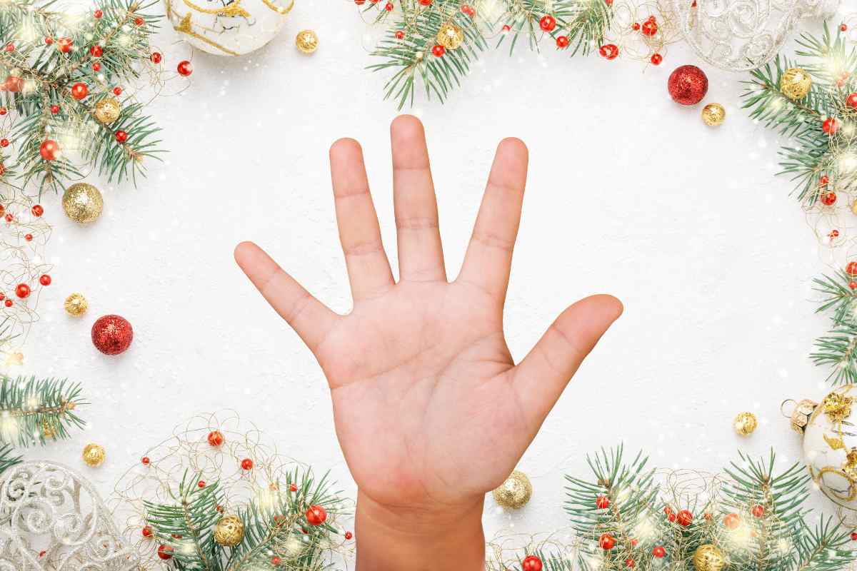 mano con numero cinque e decorazioni natalizie