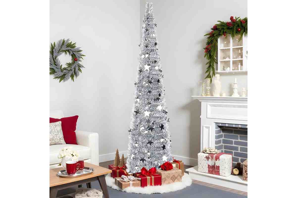Albero di Natale slim argentato con paillettes e decorazioni a forma di stella vicino a un caminetto