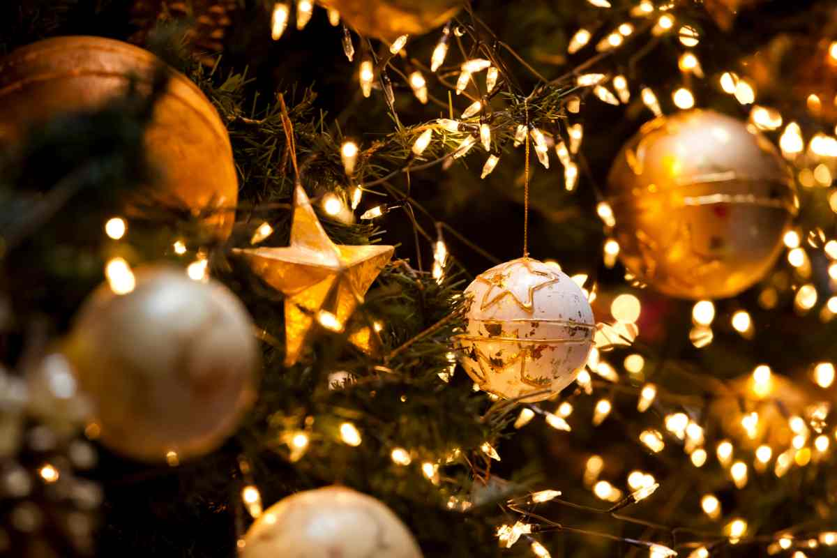 un albero di natale visto da vicino con palline, decorazioni e luci LED accese