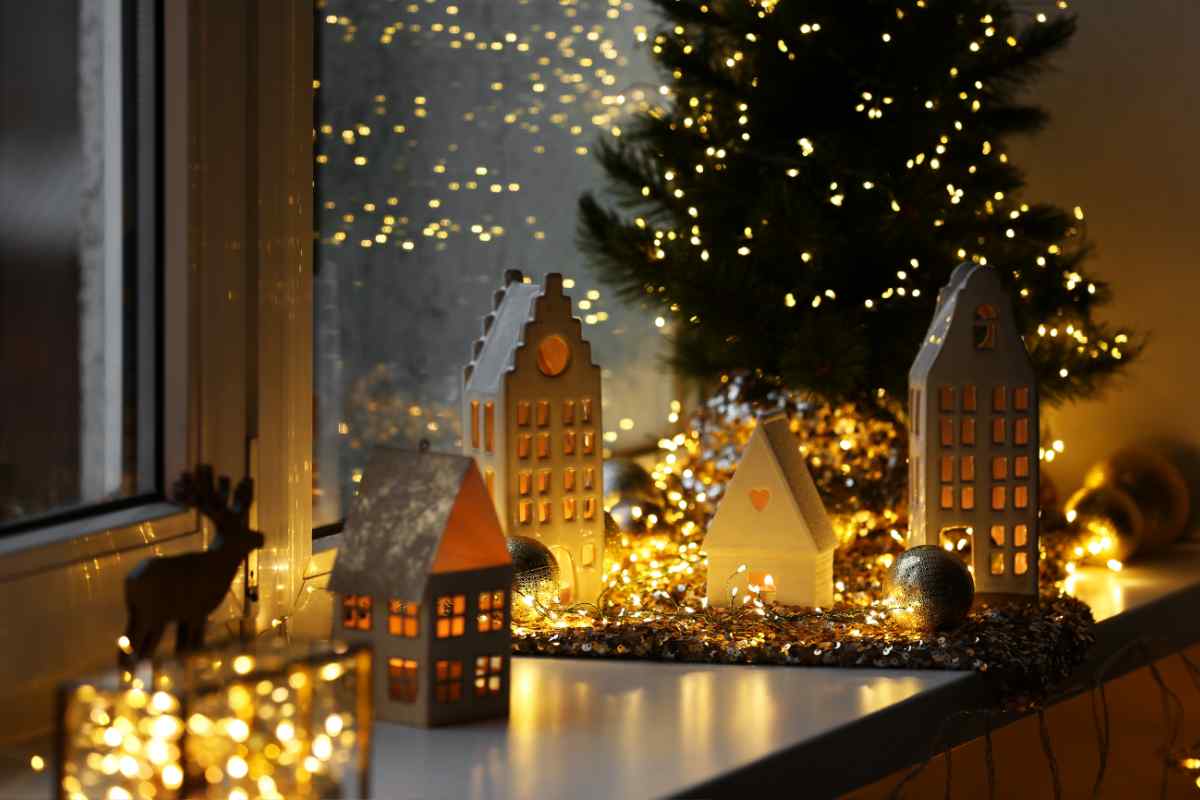 un angolo di casa con casette e albero illuminati con le luci LED di Natale