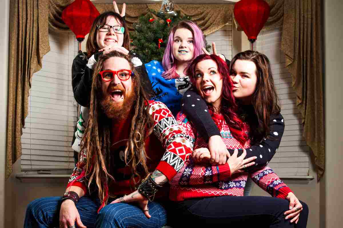 amici sorridenti che indossano maglioni natalizi