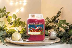 una giara di Yankee Candle in offerta su Amazon posta su un vassoio con diverse palline di Natale intorno