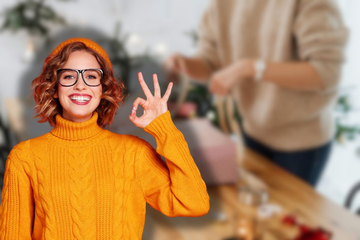 donna che fa pacchetti da regalo e un'altra sorridente che fa ok con le mani