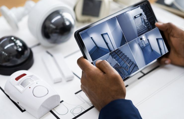 uomo che controlla telecamere di sicurezza