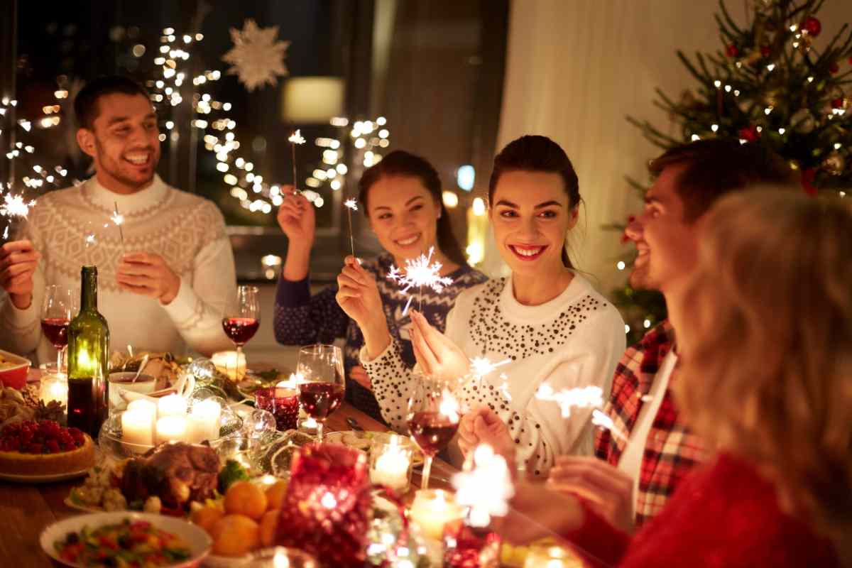 amici intorno al tavolo in sala da pranzo la sera di Natale